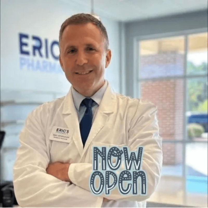 A man in white lab coat holding up an open sign.
