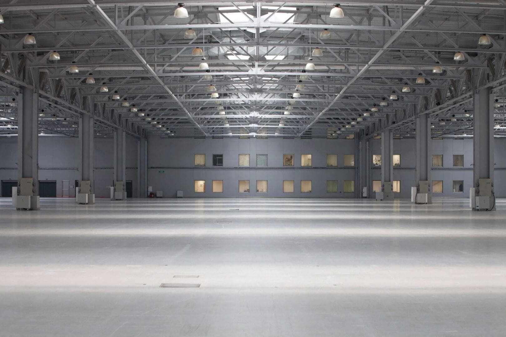 A large empty warehouse with lights on the ceiling.