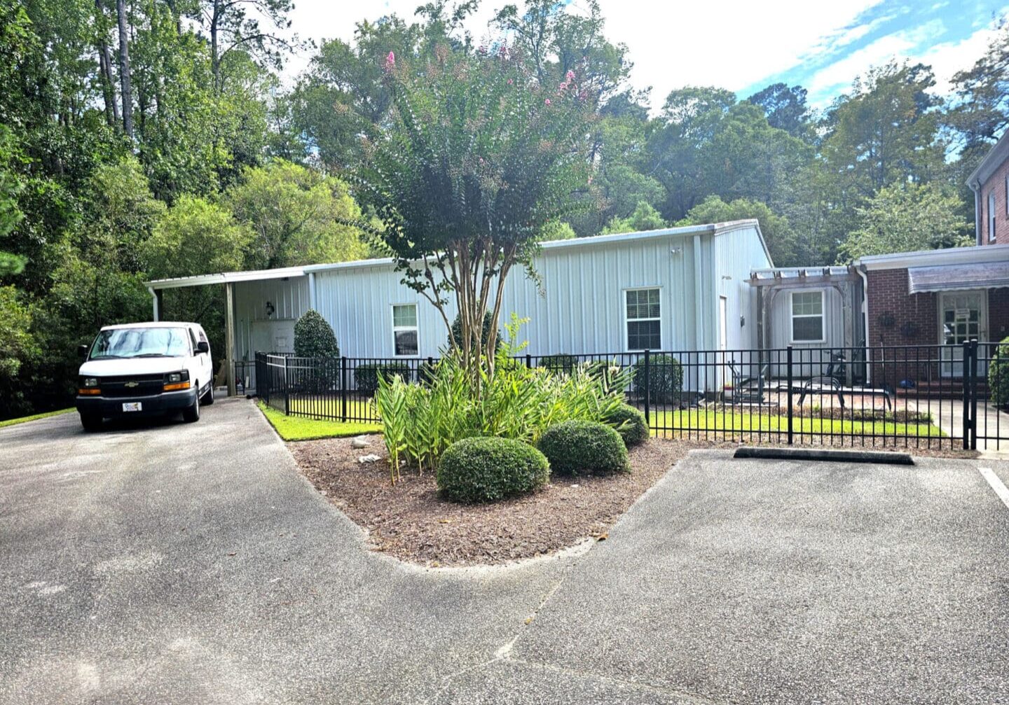 White van parked beside a metal building.
